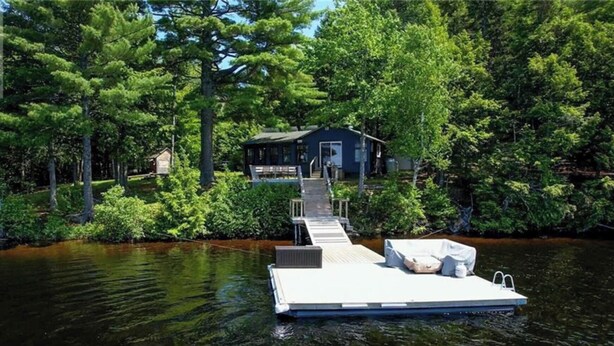 A dock extending into a lake with a house at the end. - Come play in the water at this secluded get away.
Observe nature at its best.
 (Little Ridge)