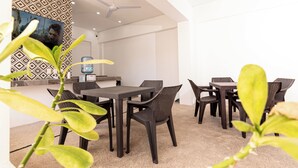 Un comedor con una mesa, sillas, un ventilador de techo y una pared con diseño.