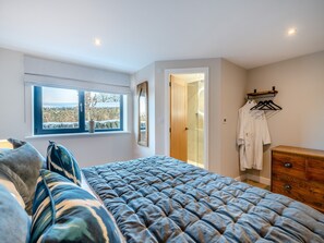 A bedroom with a bed, a window with a view, a wooden dresser, and a walk-in closet. - Moorgate Lodge - UK47742 (Kelbrook)