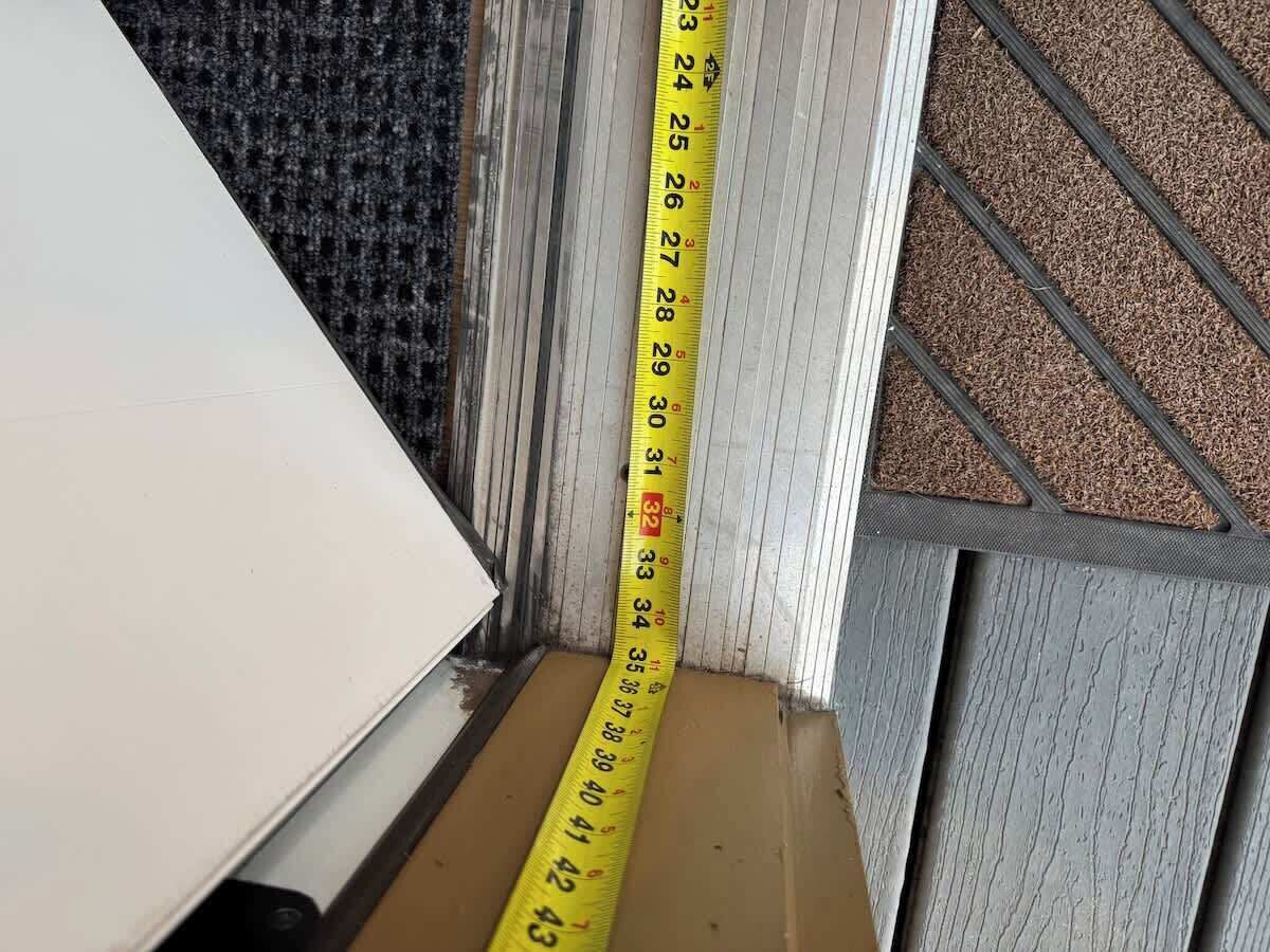 Un ruban à mesurer jaune est placé contre un mur, indiquant une dimension d’espace.