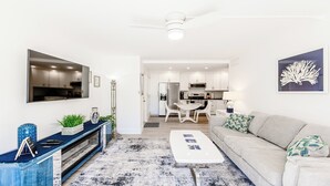 A modern living room with a sofa, coffee table, and a dining area with a table and chairs. - Discover the perfect getaway at Villa De Marco East, (Marco Island)