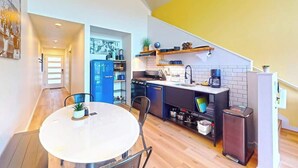 Une cuisine compacte avec un coin repas, comprenant une table ronde, des chaises et une petite plante en pot.