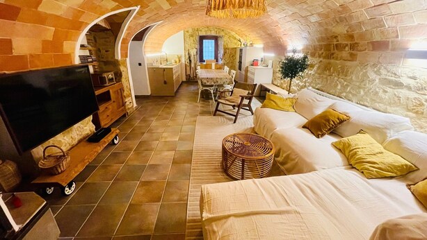 A cozy living room with a TV, sofa, and dining area. - Village house in Palamós (Palamós)