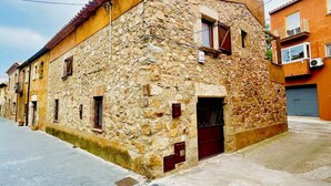 A stone building with a tiled roof, a wooden door, and a small window. - Village house in Palamós (Palamós)