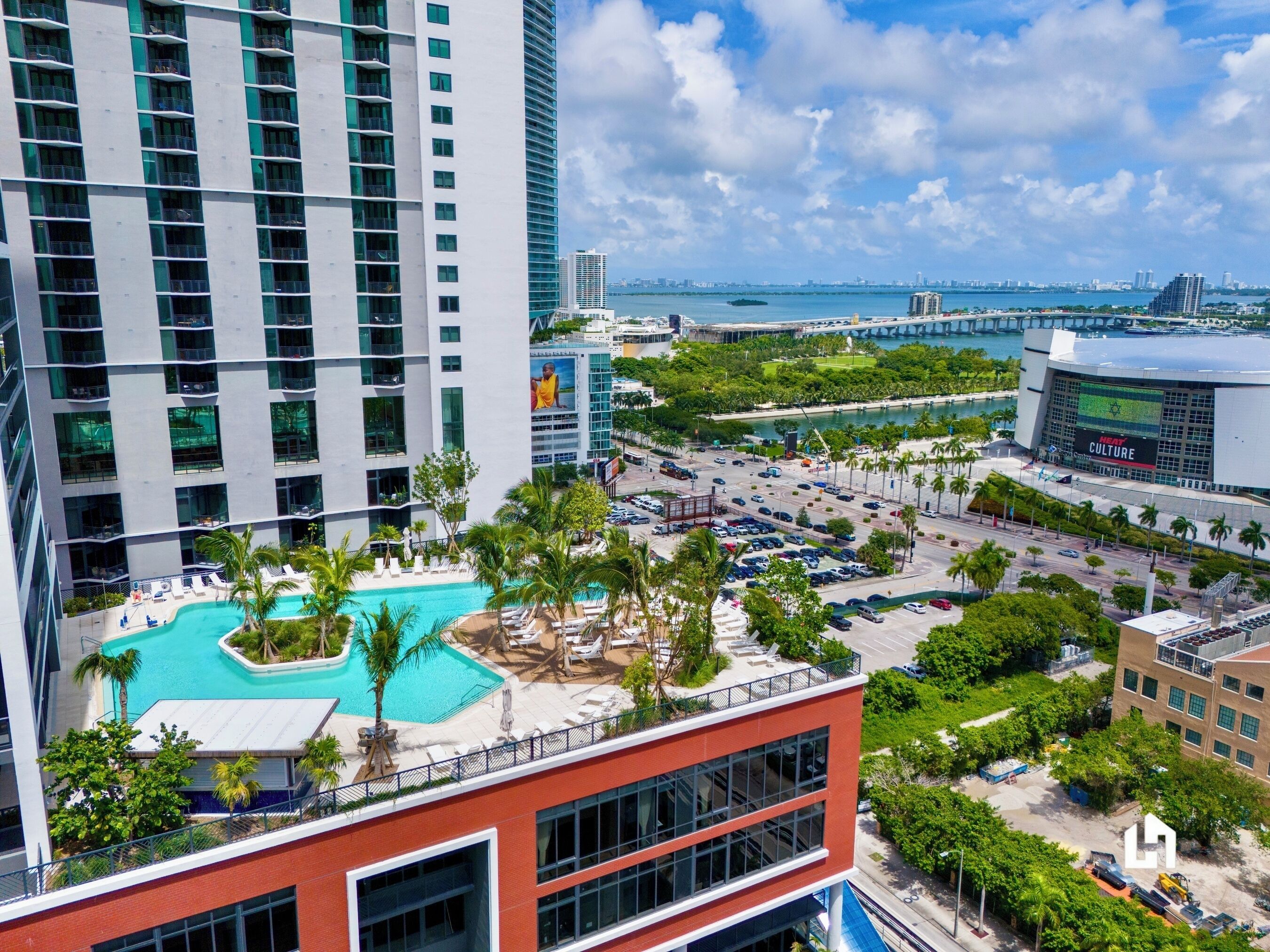 A modern hotel with a rooftop pool, a view of the city skyline, and a large building with a digital display.