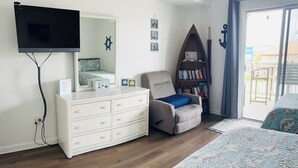 A bedroom with a bed, a dresser, a chair, a bookshelf, and a television. - Relisted!Ocean Blk, Bay&Ocean view, steps to beach best food & bars 2 Full Baths (Ocean City)