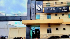Un hotel con un cartello ben visibile che riporta "SERRAS PALACE HOTEL" e un grande logo a forma di 'S'.