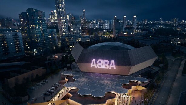 A modern stadium with a large illuminated 'ASB' sign, surrounded by a spacious plaza and a cityscape in the background. - Spacious 4-Bedroom Home | Driveway & Garden (Greater London)