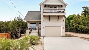 A two-story house with a garage, a balcony, and a front porch. - Book Labor Day | Hot Tub + Grill | Pet-Friendly! (Canyon Lake)