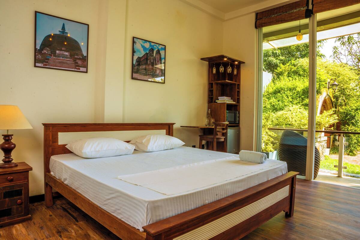 A bedroom with a wooden bed, a nightstand, a lamp, and a bookshelf.