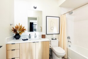 Un baño moderno con lavamanos, inodoro y bañera.