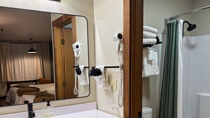 A bathroom with a sink, mirror, hairdryer, and towel rack. - New Room by Silver Dollar City + Shuttle + Pool (Branson)