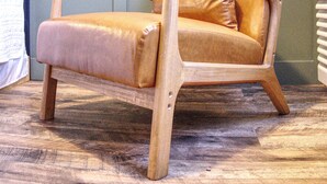 A chair with a wooden frame and leather upholstery, placed on a wooden floor. - New Room by Silver Dollar City + Shuttle + Pool (Branson)
