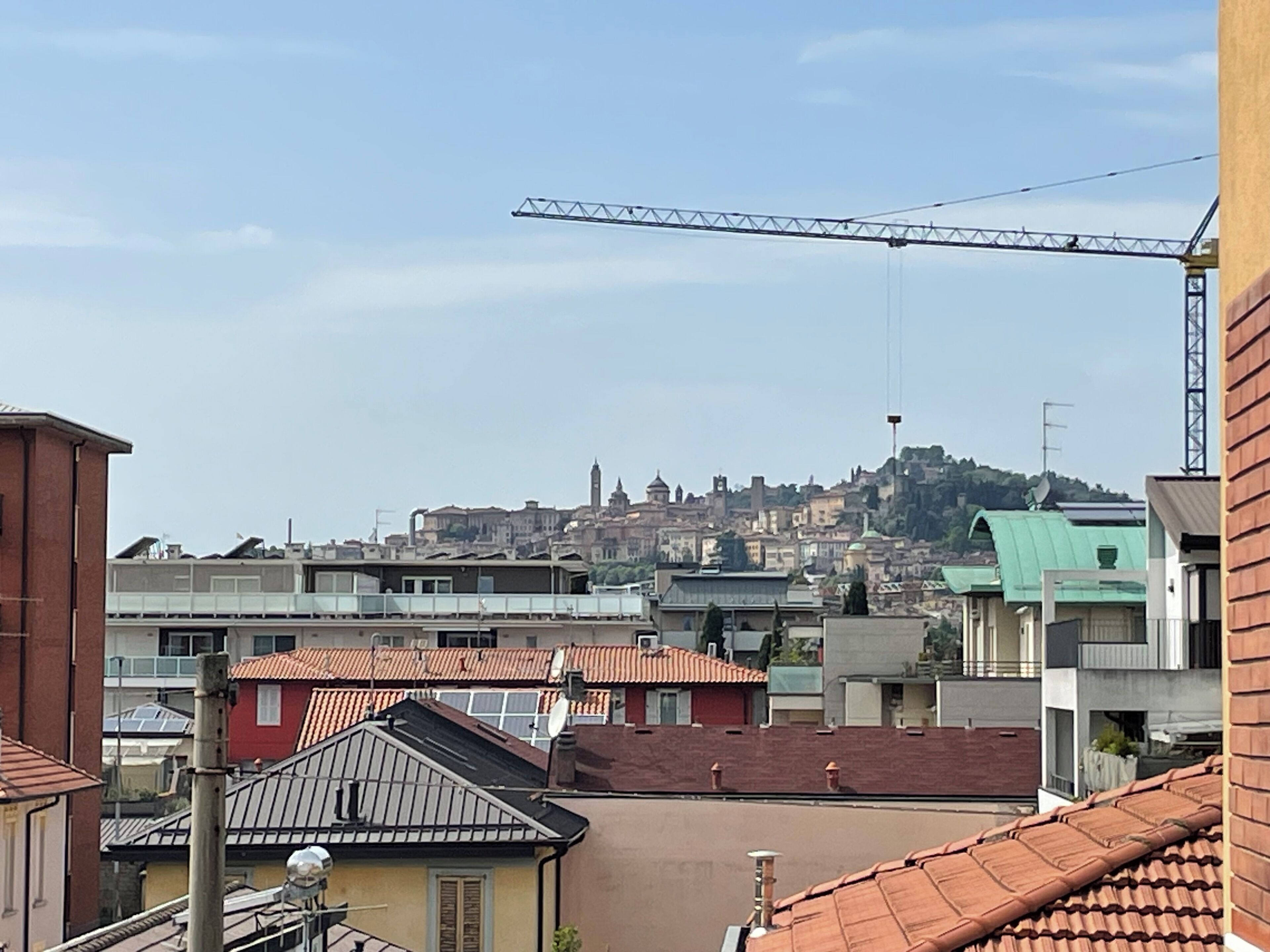 A residential area with a view of a hilltop cityscape.