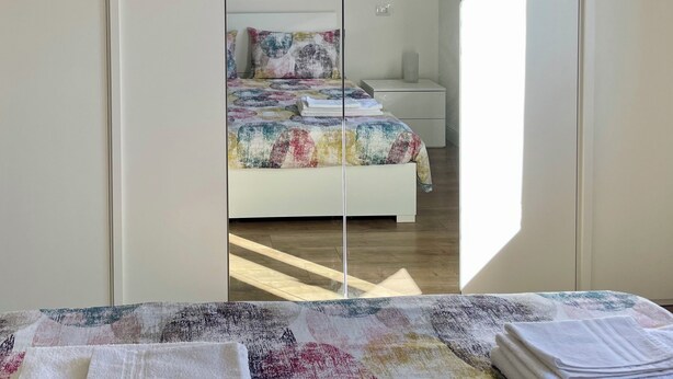 Un dormitorio con cama, mesita de noche y velador.