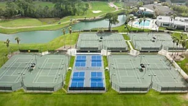 Un campo de golf con varias canchas de tenis y una piscina.