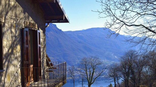 A stone building with a balcony overlooking a lake and mountains. - Beautiful cottage a few miles from Bellagio with stunning views of Lake Como (Civenna di Bellagio)