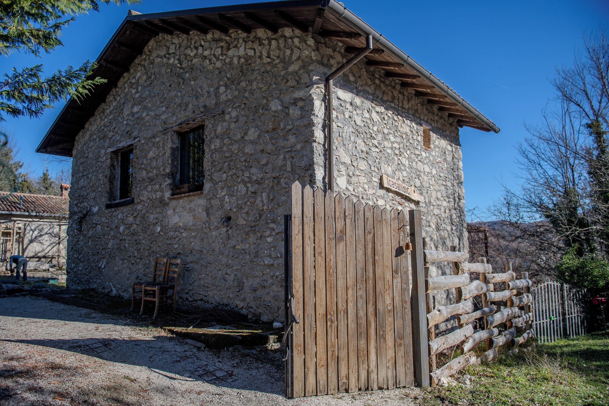 Un edificio de piedra con puerta y cerca de madera.