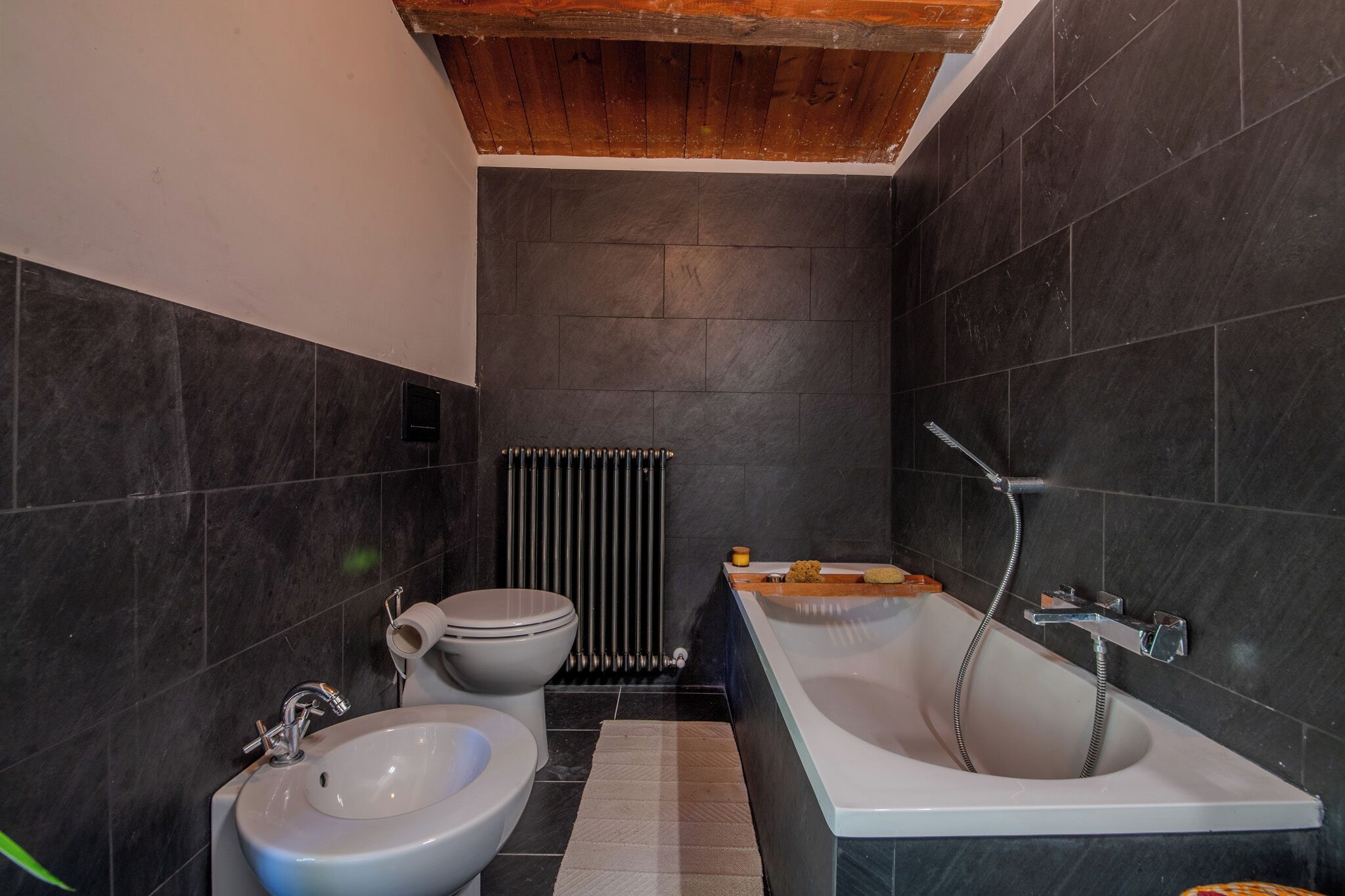 Een moderne badkamer met een wit wastafel, toilet en bad.
