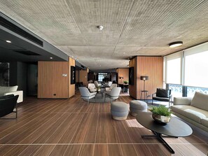 Relax in a spacious lounge area with a high ceiling, comfortable seating, and a central coffee table.