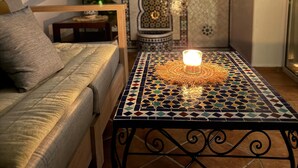 Un coin salon confortable avec un canapé moelleux et une petite table sur laquelle est posée une bougie.