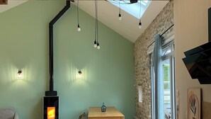 Une cuisine moderne équipée d’un poêle à bois, d’une table à manger et d’un îlot central.