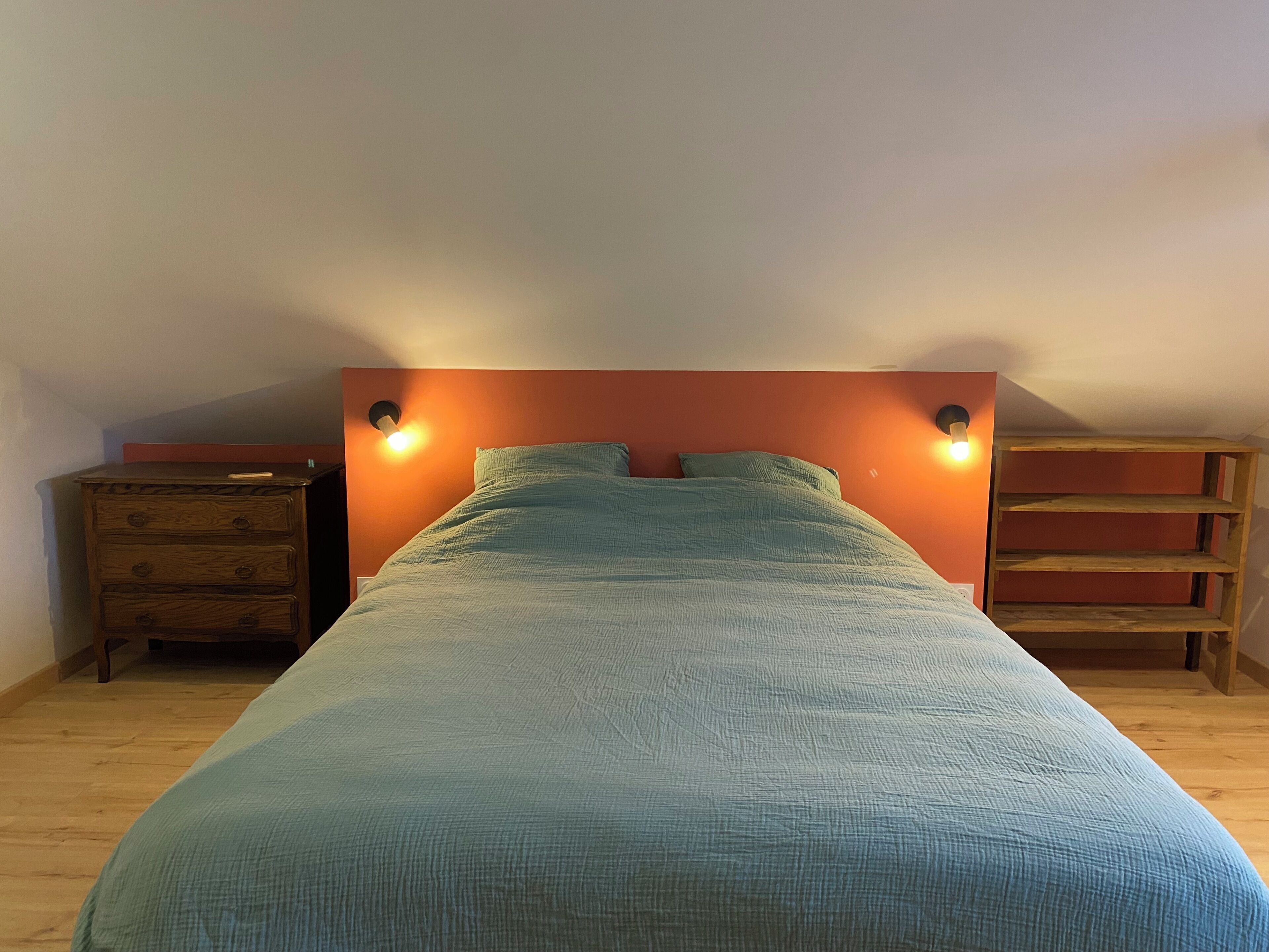 Un dormitorio con una cama, un aparador y una estantería.