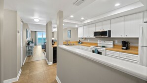 A modern kitchen with white cabinets, a microwave, and a coffee maker. - Oceanfront 2BR Condo with Stunning Ocean Views and Beach Access, 505 (Indian Harbour Beach)