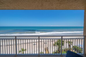 Un balcon avec vue sur la plage et l’océan.