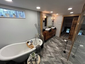 Relax in a spacious bathroom with a bathtub, two sinks, and a vanity.