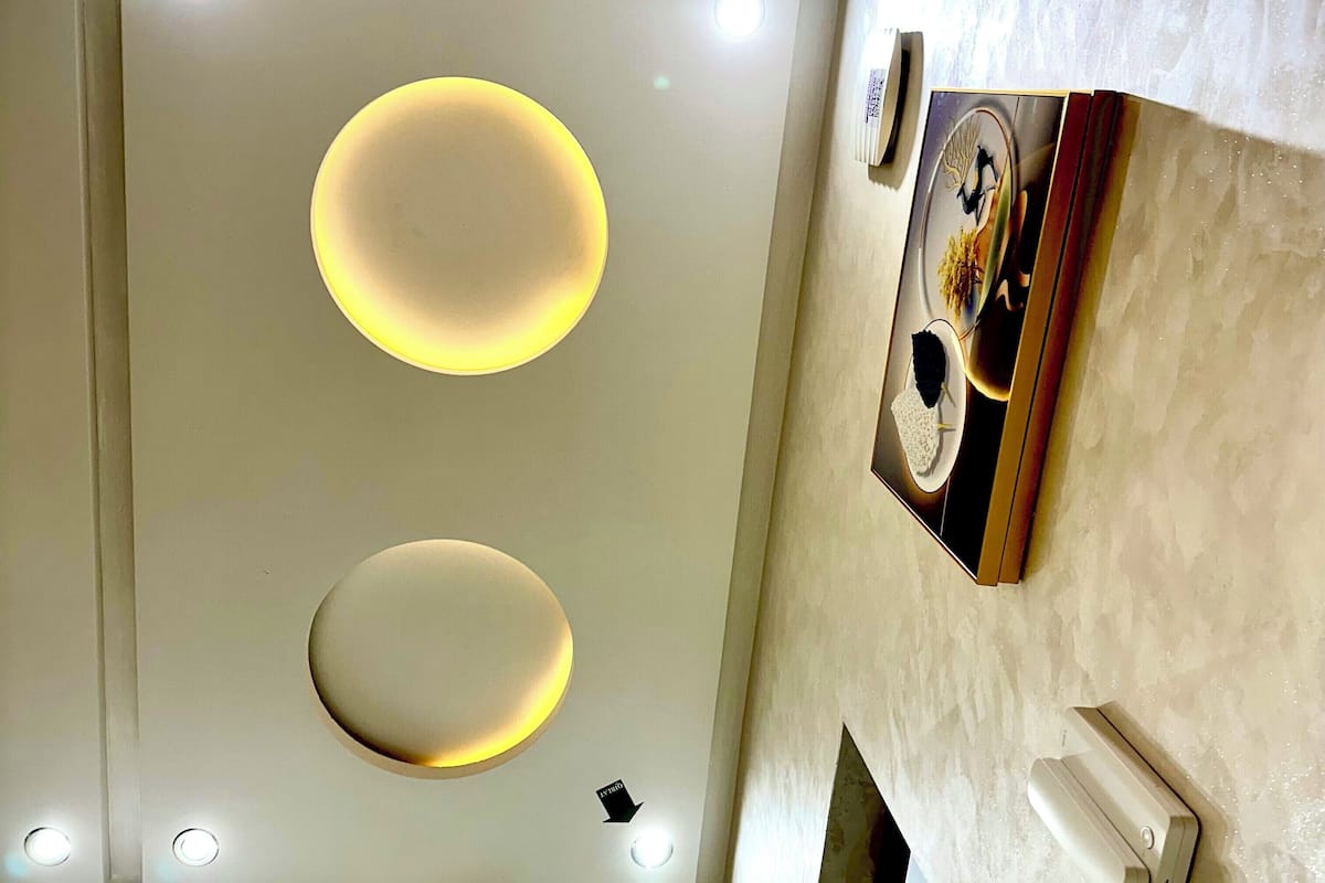 A modern bathroom with recessed lighting, a toilet, and a sink.