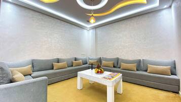 A modern living room with a sectional sofa, a coffee table, and a decorative light fixture.