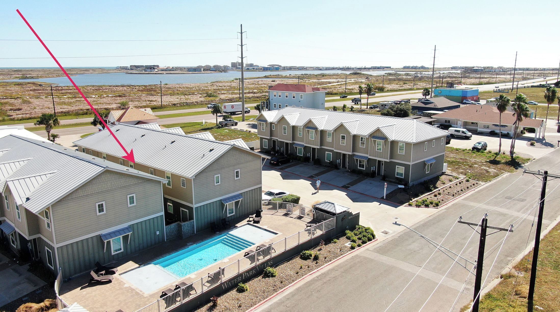 A residential area with houses, a swimming pool, and a road.