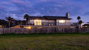 A modern two-story house with a wooden deck, large windows, and a fenced yard. - Mendel Manor by Avantstay Walk to Beach Large Deck Patio (Oceano)