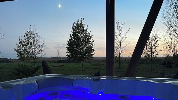 Un bain à remous avec vue sur un paysage verdoyant et des arbres.