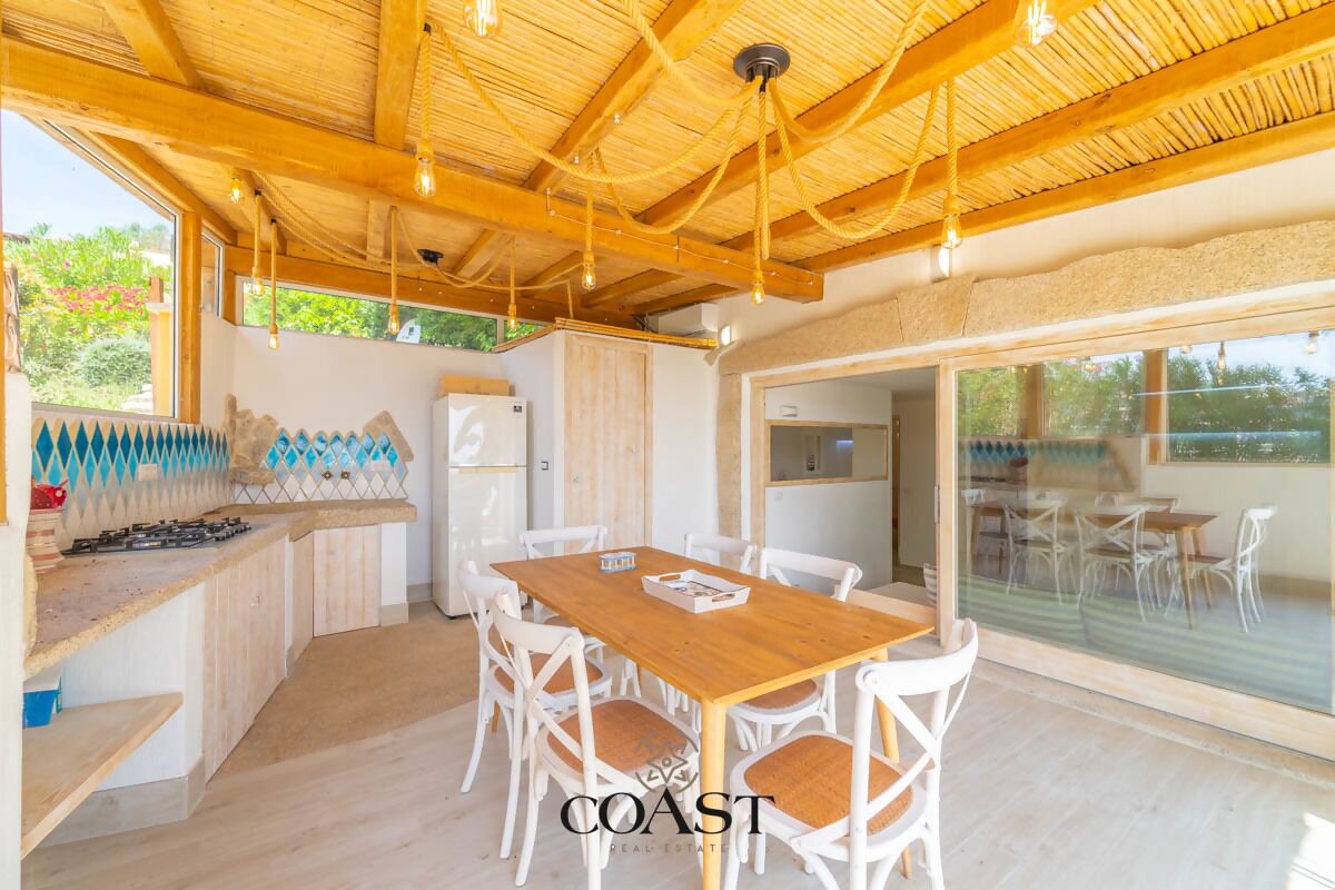 A spacious kitchen with a wooden table and chairs, a built-in stove, and a refrigerator.