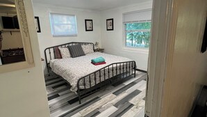 Ein Schlafzimmer mit Bett, Fenster und Tür.