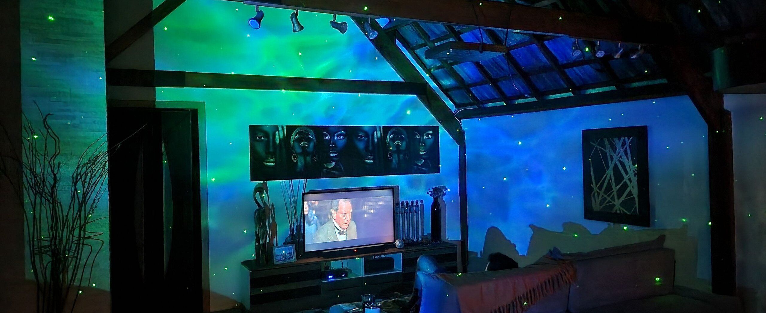 Ein Zimmer mit Fernseher, einem gerahmten Bild und einer Zierdecke.