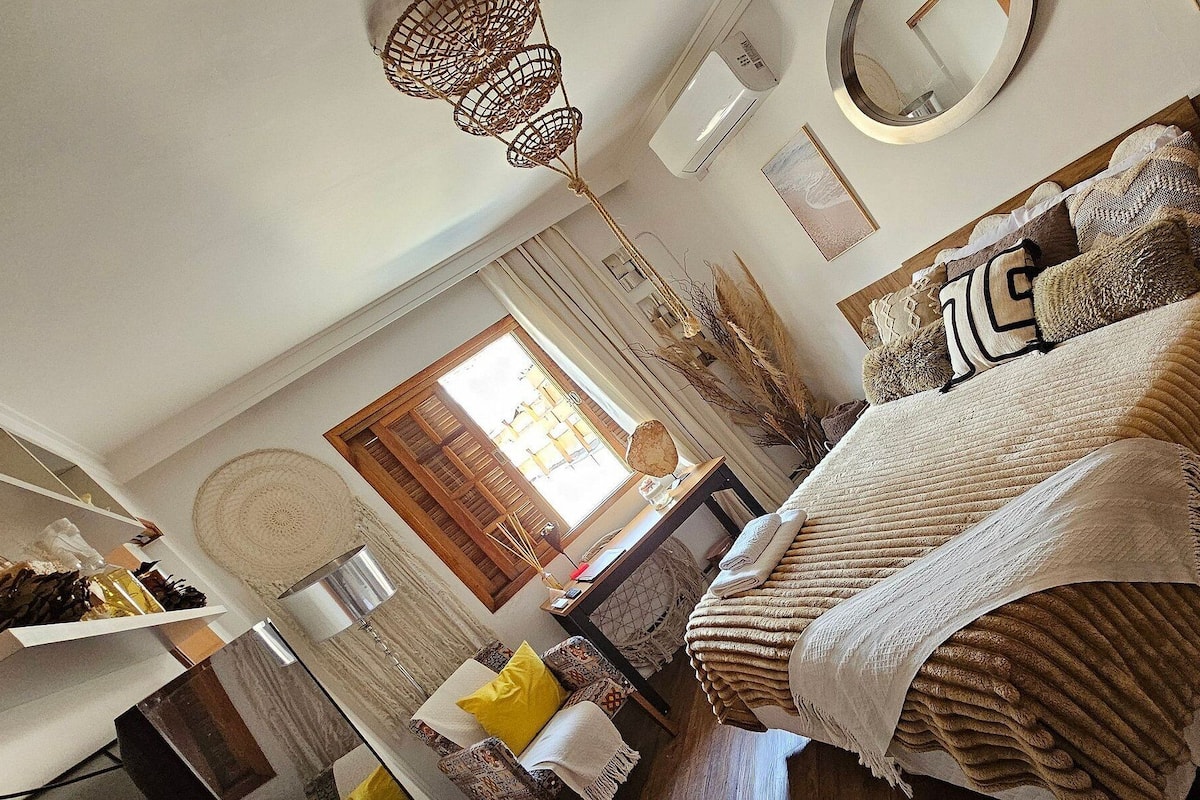 A cozy bedroom with a large bed, a wooden headboard, and a bedside table.