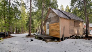 A log cabin with a wooden exterior, a metal roof, and a small porch. - Walk to Trails & Butte Creek: Cozy Retreat w/ Deck (Butte Meadows)