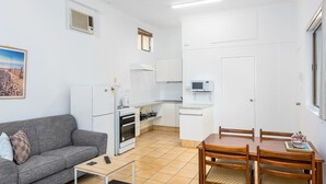 A compact living space with a kitchenette, a dining area, and a sofa.