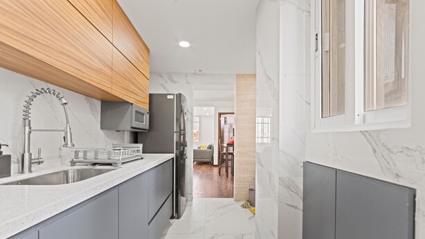 A modern kitchen with grey cabinets, a stainless steel sink, and a built-in microwave. - Spacious Flat with 2 Bedrooms in CDMX (Mexico City)