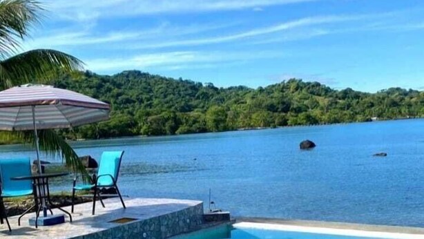 A clear blue pool with a view of a tropical landscape and a distant island. - ScubaPortobelo (Portobelo)