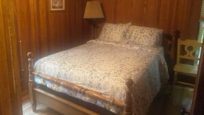 A wooden-paneled room with a bed, a chair, and a lamp. - Angola on the Lake Beach Front House  4BR  private beach wrap-around porches (Angola)