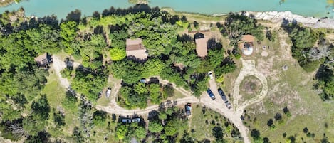 Vista aérea de una propiedad con un lago, varios edificios y un camino sinuoso.