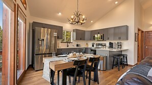 A modern kitchen with a central island, stainless steel appliances, and a chandelier. - Luxe• Mtn views• Sauna• Hot tub• 2 King Beds• Game Room• Close to Breck (Fairplay)