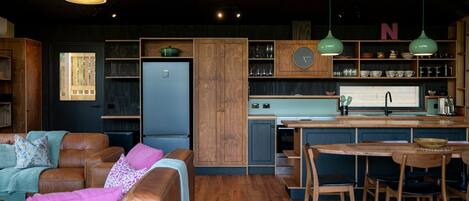 A compact kitchen with wooden cabinets, a built-in fridge, and a bar area.