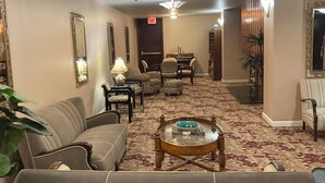 A hotel lobby with a sofa, armchairs, a coffee table, a piano, and a bookshelf. -  1-bedroom condo in Long Beach with 2 private patios.  (Long Beach)