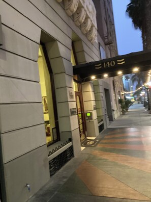 A building entrance with a sign reading "140" and a covered walkway.