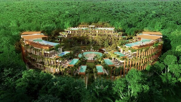 A resort with a central circular pool, surrounded by multiple buildings with green roofs, set in a lush green environment. - Chic 2-bedroom penthouse with private pool, gym, WiFi, W/D & Concierge (Tulum)
